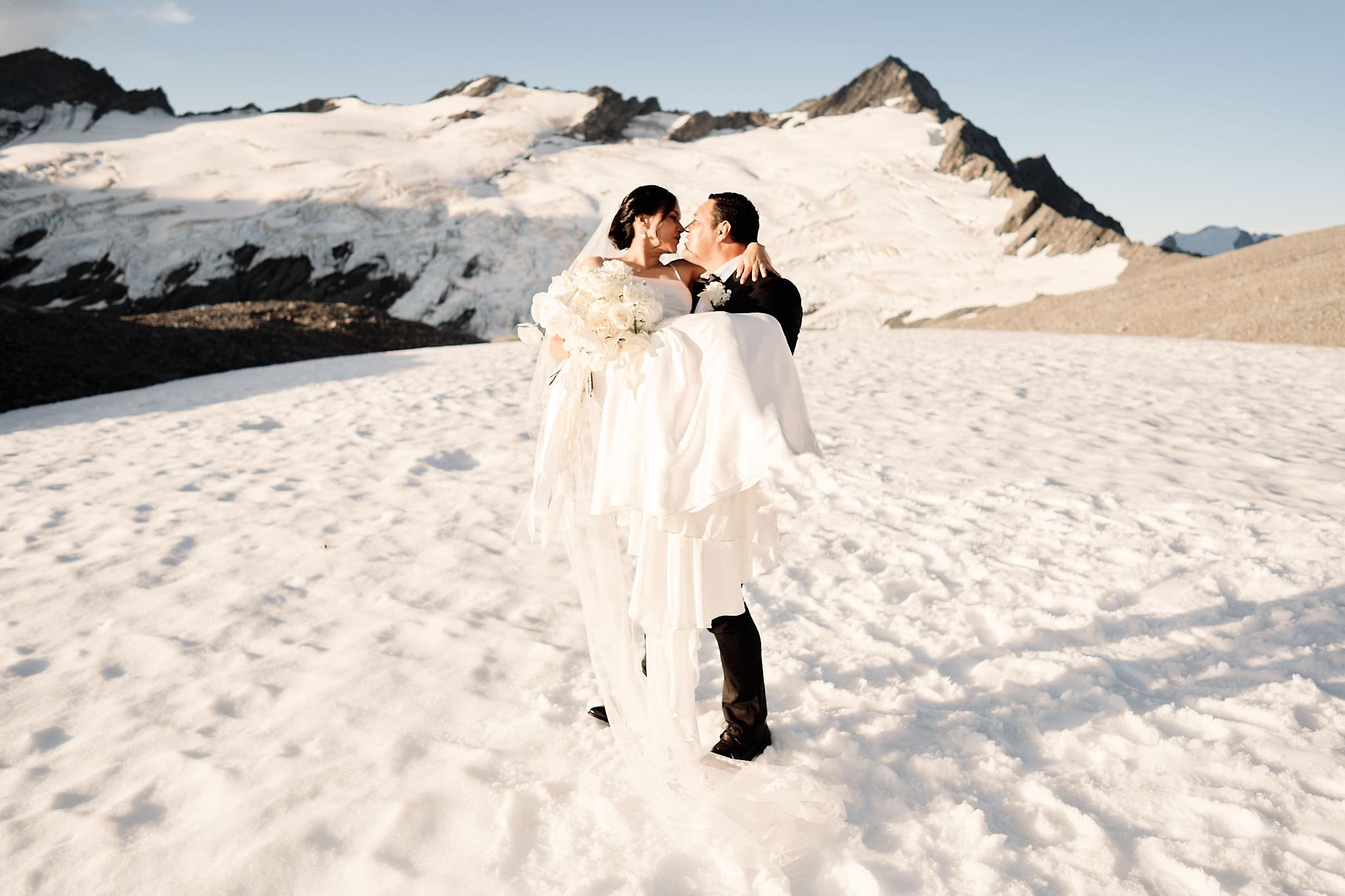 クイーンズタウン　ニュージーランド　ウェディング　前撮り　挙式　結婚式　フォトグラファー | 雪に気づいた山の頂上で、とてもなクイーンズタウンのヘリウェディングを体験する新婦と新郎。エロロープメントは感動しないでください。
